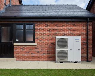 a heat pump outside a house - Wildwood-Panasonic-Primrose