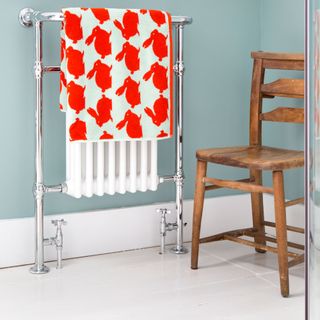 blue bathroom with heated towel rail and wooden chair