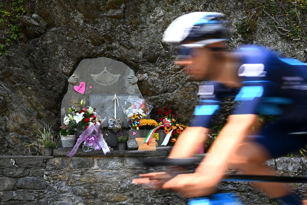 Riders pass a monument in memory of Wouter Weylandt of Belgium who died at Passo Del Bocco in 2011 during the 105th Giro dItalia