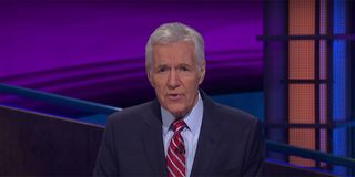 Alex Trebek addressing the audience while hosting Jeopardy.