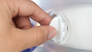 woman adjusting fridge thermostat