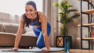 Woman performing mountain climber exercise at home