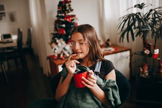 woman in glasses eating a cookie