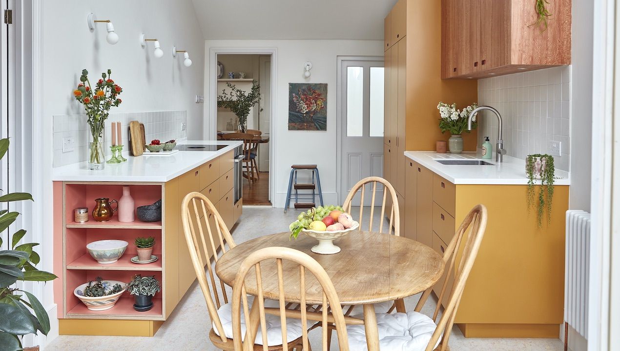 colourful galley kitchen with round dining table and chairs