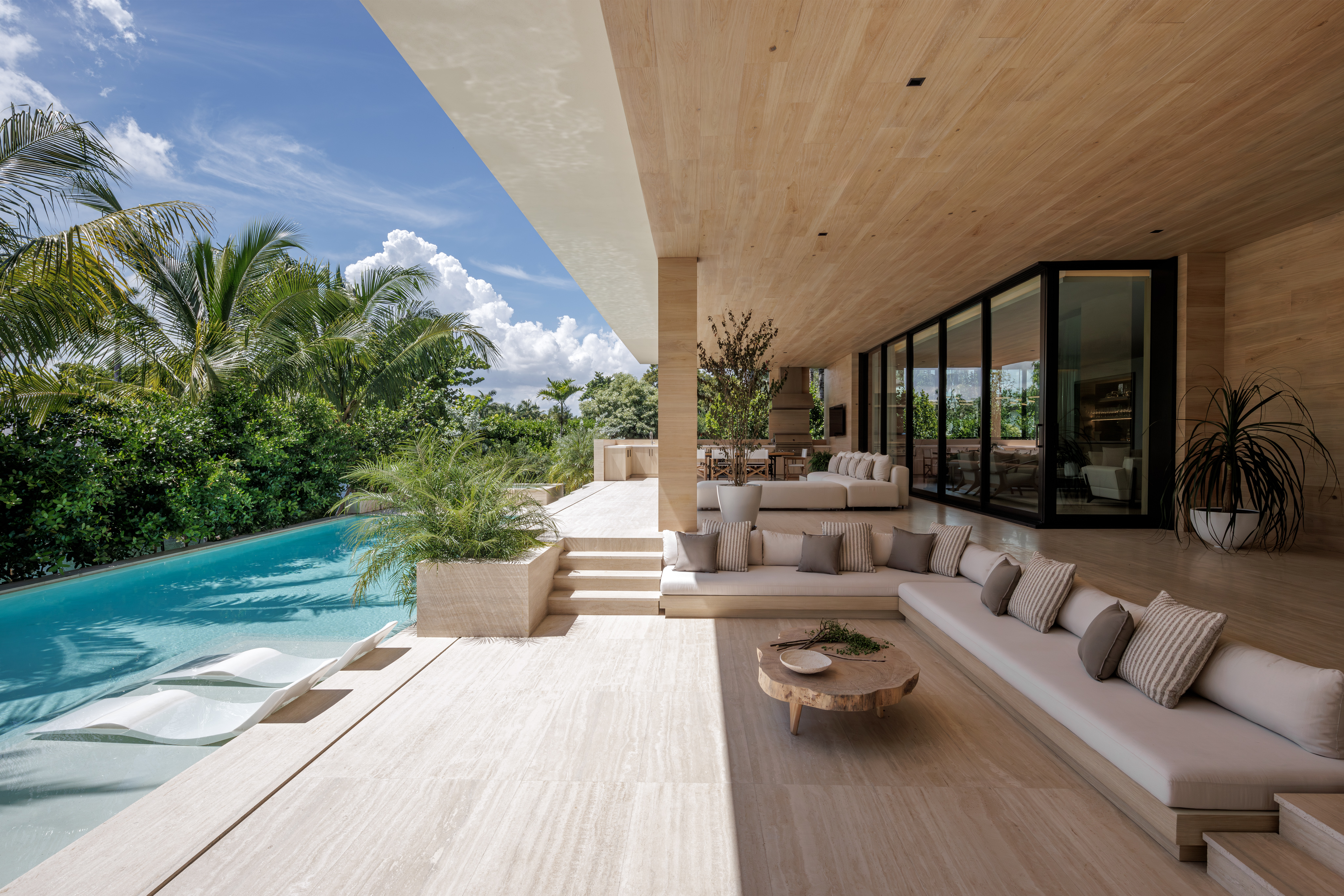 Sunset Island Residence by Strang Design view of indoor outdoor relationship in living space and swimming pool