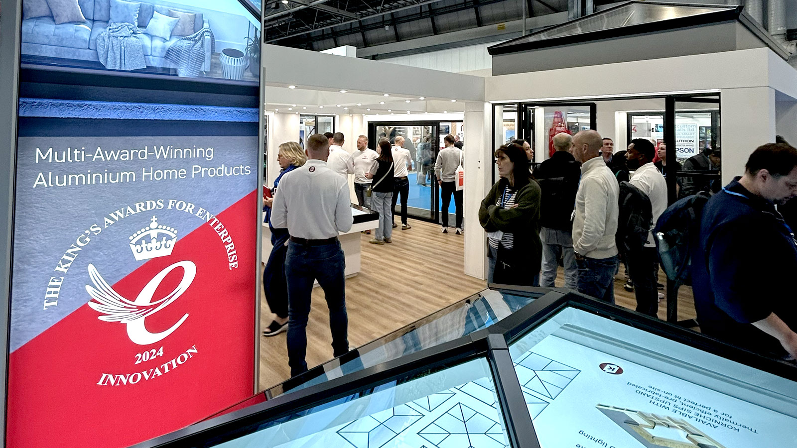 People walking around Korniche stand at HBR show with roof lantern model in foreground