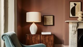 a table lamp on a sideboard in a red room