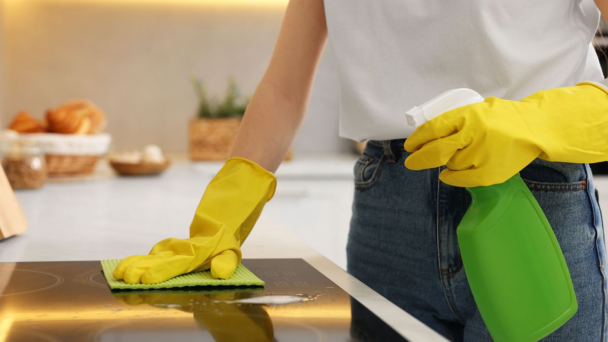 Woman cleaning induction cooktop