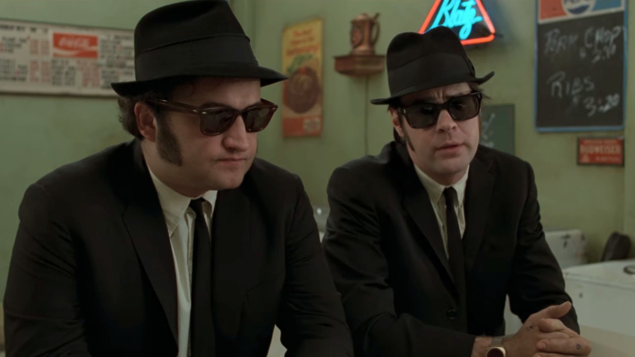 The Blues Brothers sitting together at a diner counter.