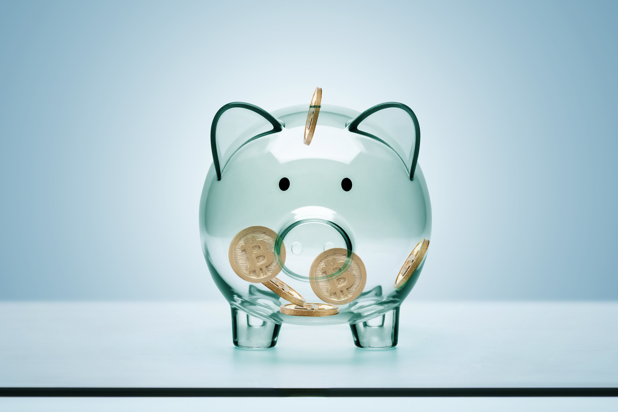 3D of Transparent Glass Piggy Bank and Bitcoin against a white background.
