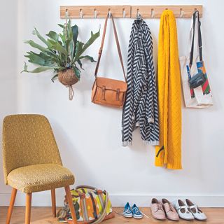 hallway with clothes hanging rack and armchair