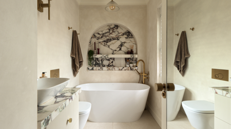 A spa-like neutral bathroom with a striking arched marble niche centred over the bathtub, next to a brown towel hanging high on the wall