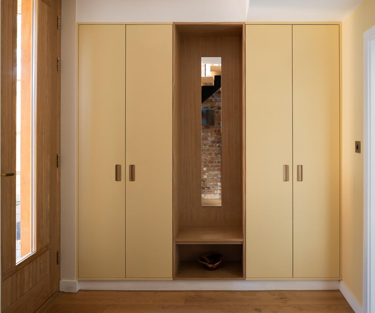 yellow built in wardrobe with wooden door to the left