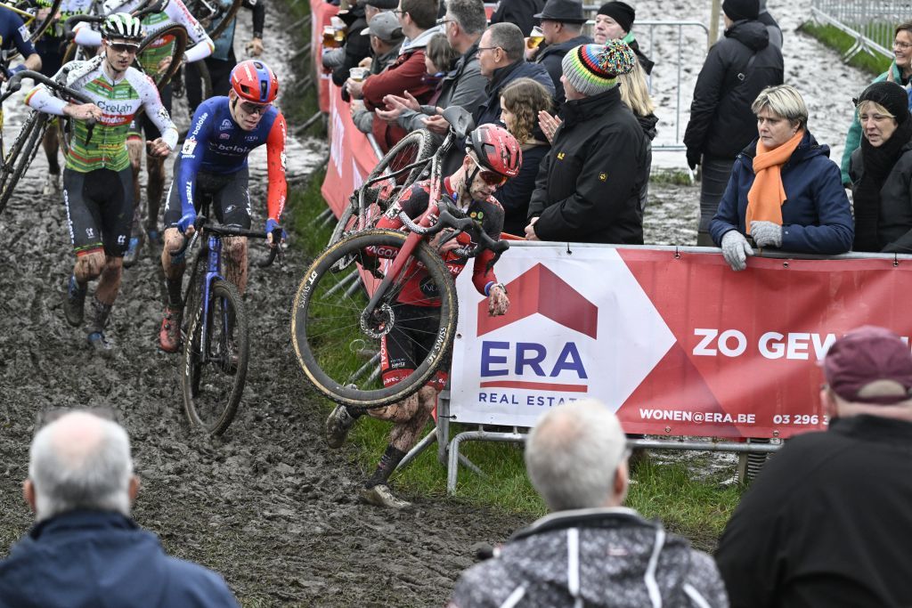Eli Iserbyt (Pauwels Sauzen-Bingoal) carries his bike ahead of Pim Ronhaar (Baloise Trek Lions)