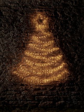Christmas tree light decoration on a brick wall