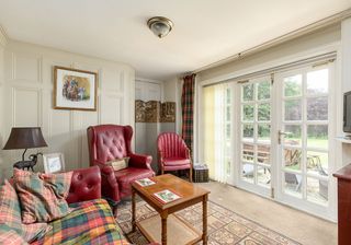 sung area with double french doors and red sofa with arm chair