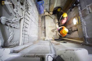 Workers remove a marble slab covering the original stone "burial bed" where Jesus Christ is said to have been laid to rest after being crucified. A layer of loose fill material is seen beneath. Scientists were surprised at how much of the original cave st