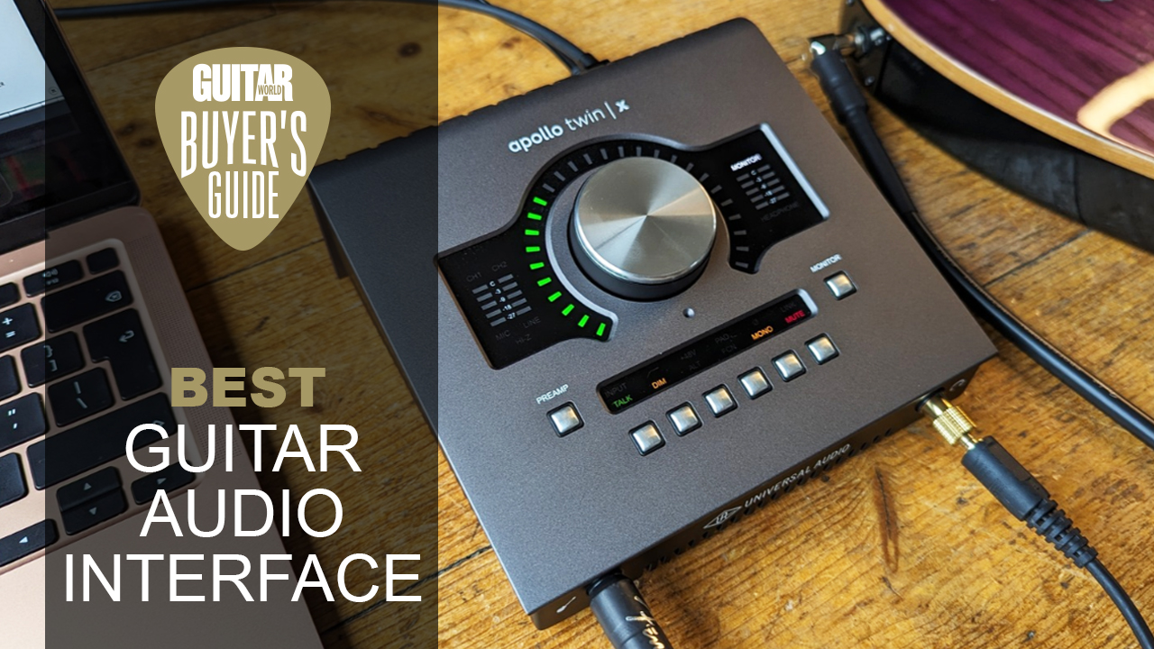 A Universal Audio Apollo Twin X interface on a wooden floor with a guitar and a laptop
