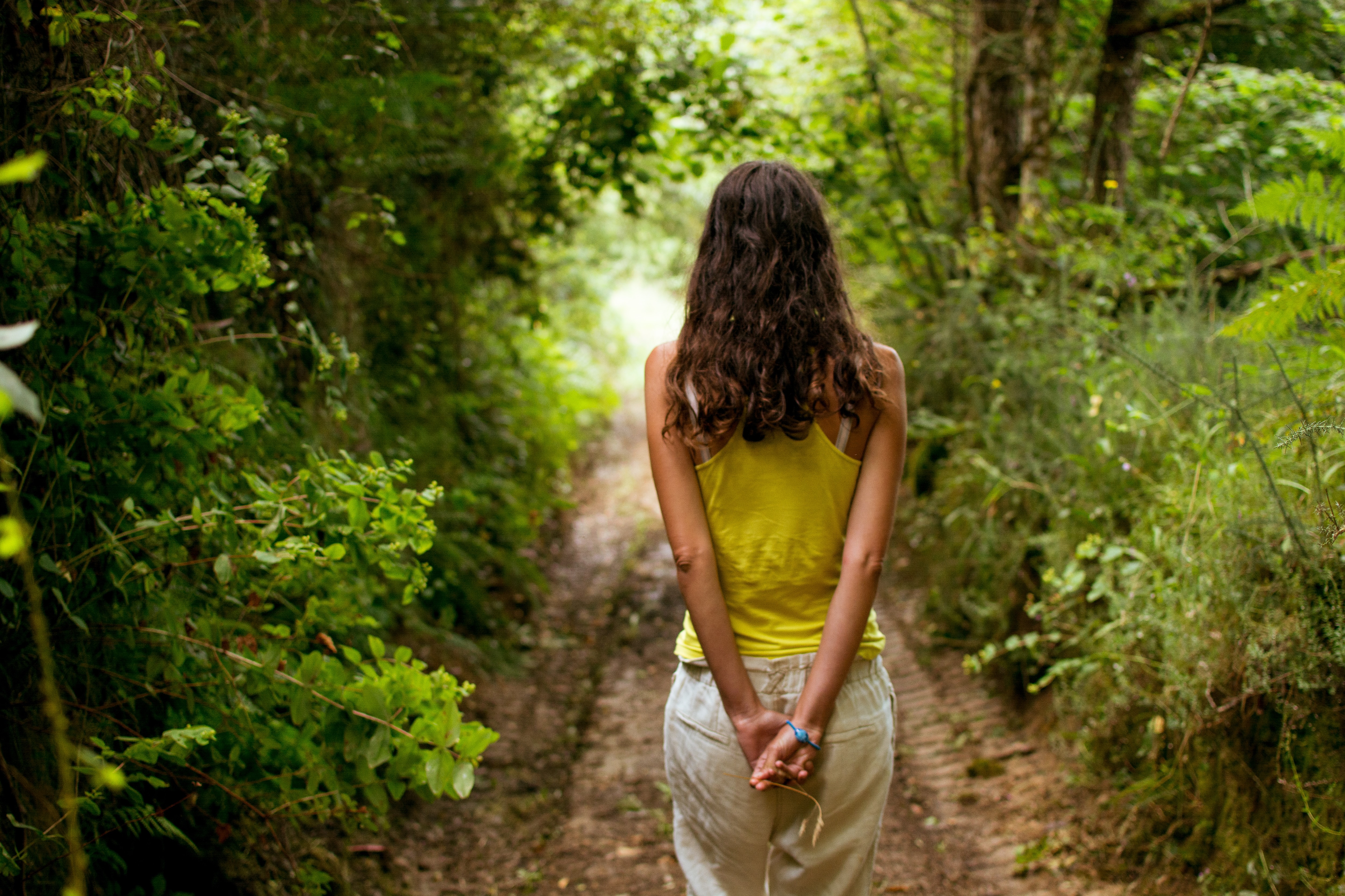A woman walks through a forest