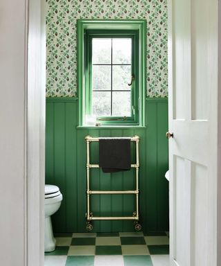 small bathroom with green painted wall panelling and patterned wallpaper