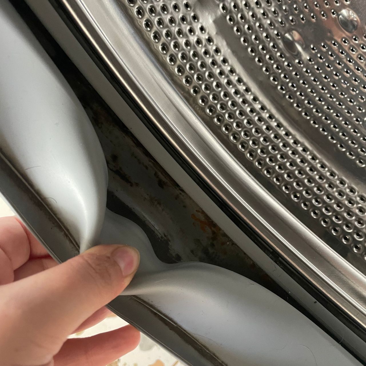 hand holding open the seal of a washing machine