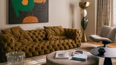 gold sofa in a grey living room with modern art above it