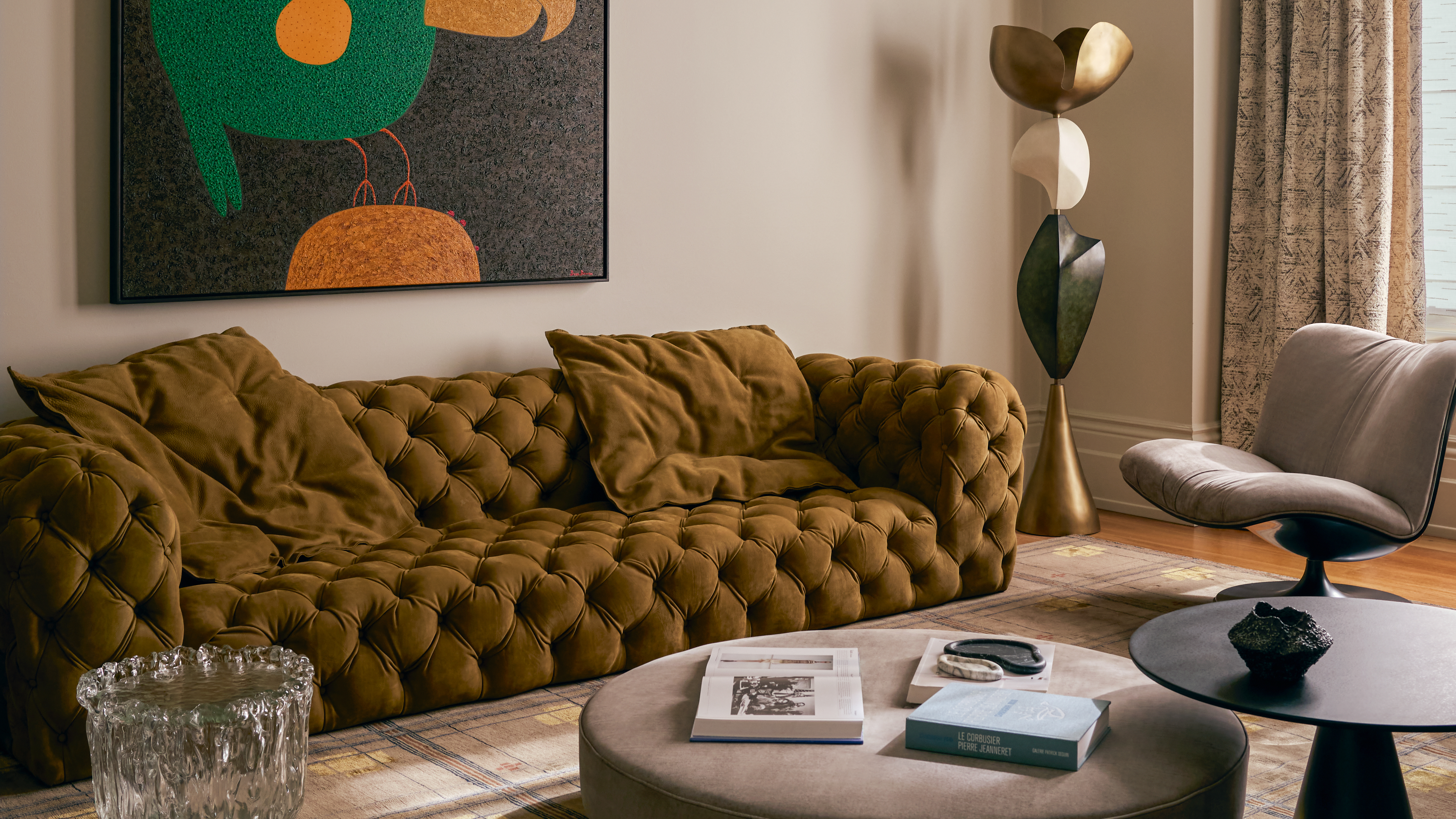gold sofa in a grey living room with modern art above it