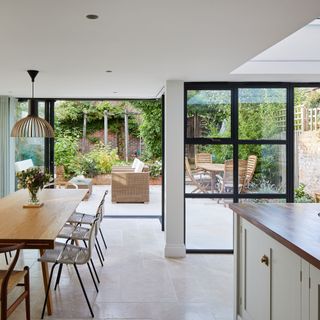 dinning area house extension with white wall glass door and wooden dinning table and chair