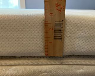 Tempur-Pedic mattress topper with tape measure showing a 3-inch measurement