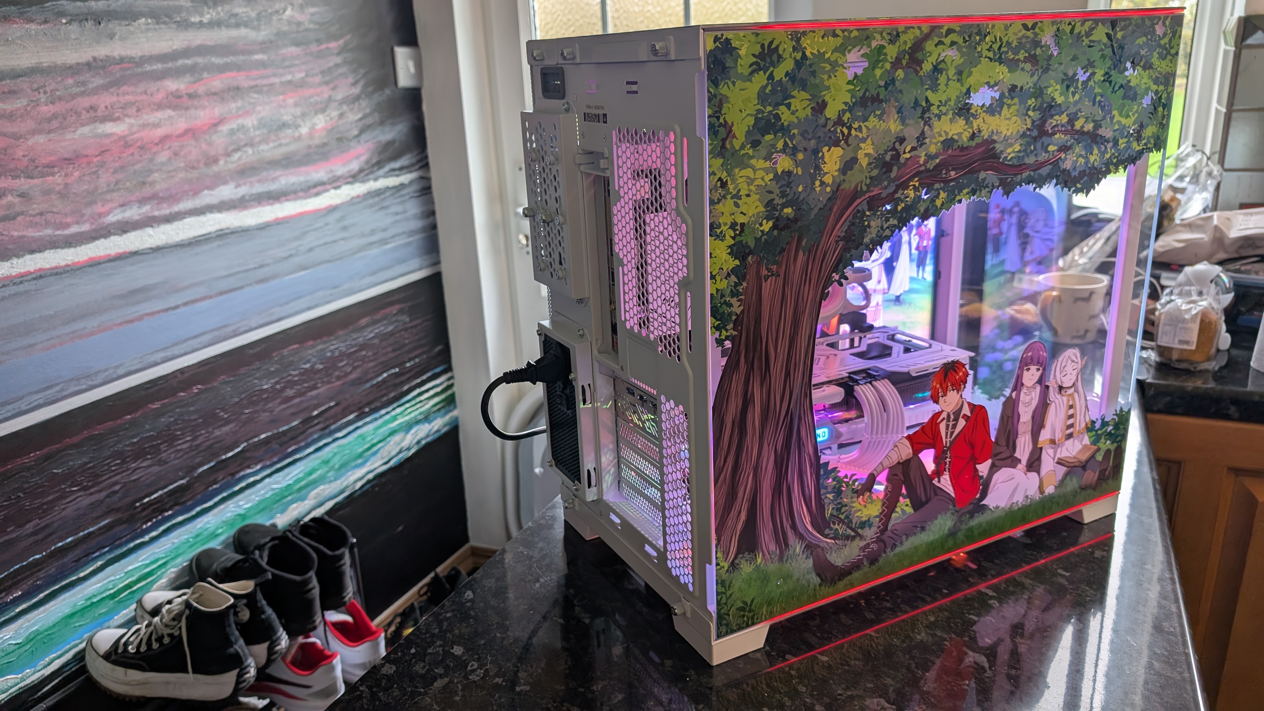 The Starforge Systems Frieren PC, photographed on a dark worktop with the RGB lighting switched on.