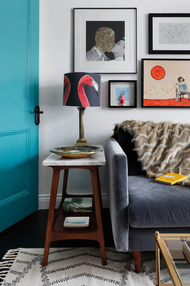 Living room with grey sofa, gallery wall and bright blue door