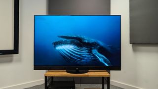 Panasonic Z95A 65-inch MLA OLED TV on wooden AV rack with whale on TV