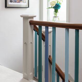 white stairway with walled picture and flower vase