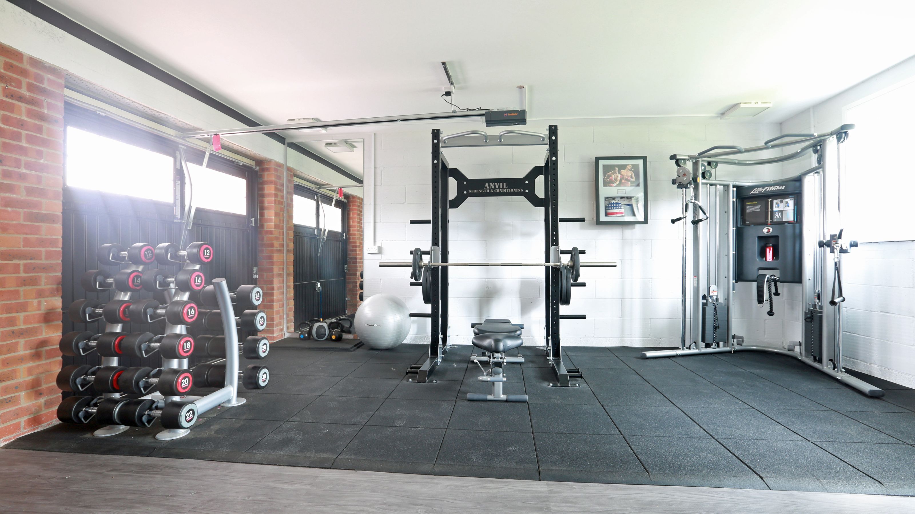 Home gym in garage with protective matting on the floor