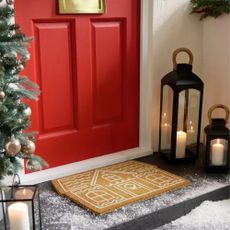Habitat Gingerbread House Christmas Doormat outside a red front door