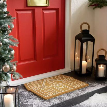 Habitat Gingerbread House Christmas Doormat outside a red front door