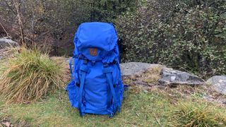 Blue Fjallraven Kajka 35 backpack sitting on the ground