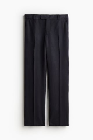 a pair of pinstripe H&M suit pants in front of a plain backdrop