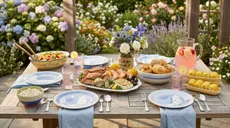 Pfaltzgraff cookware arranged on an outdoor table full off food and surrounded by flowers