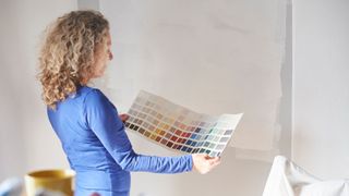 woman looking at paint swatches in her room