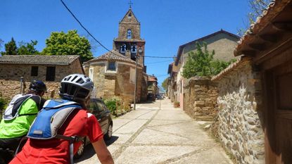 A man riding his bike through a scenic Italian town