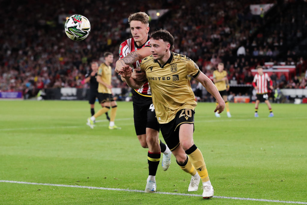 Oliver Rathbone of Wrexham battles for possession with Harry Boyes of Sheffield United during the Carabao Cup First Round match between Sheffield United and Wrexham at Bramall Lane on August 13, 2024 in Sheffield, England.