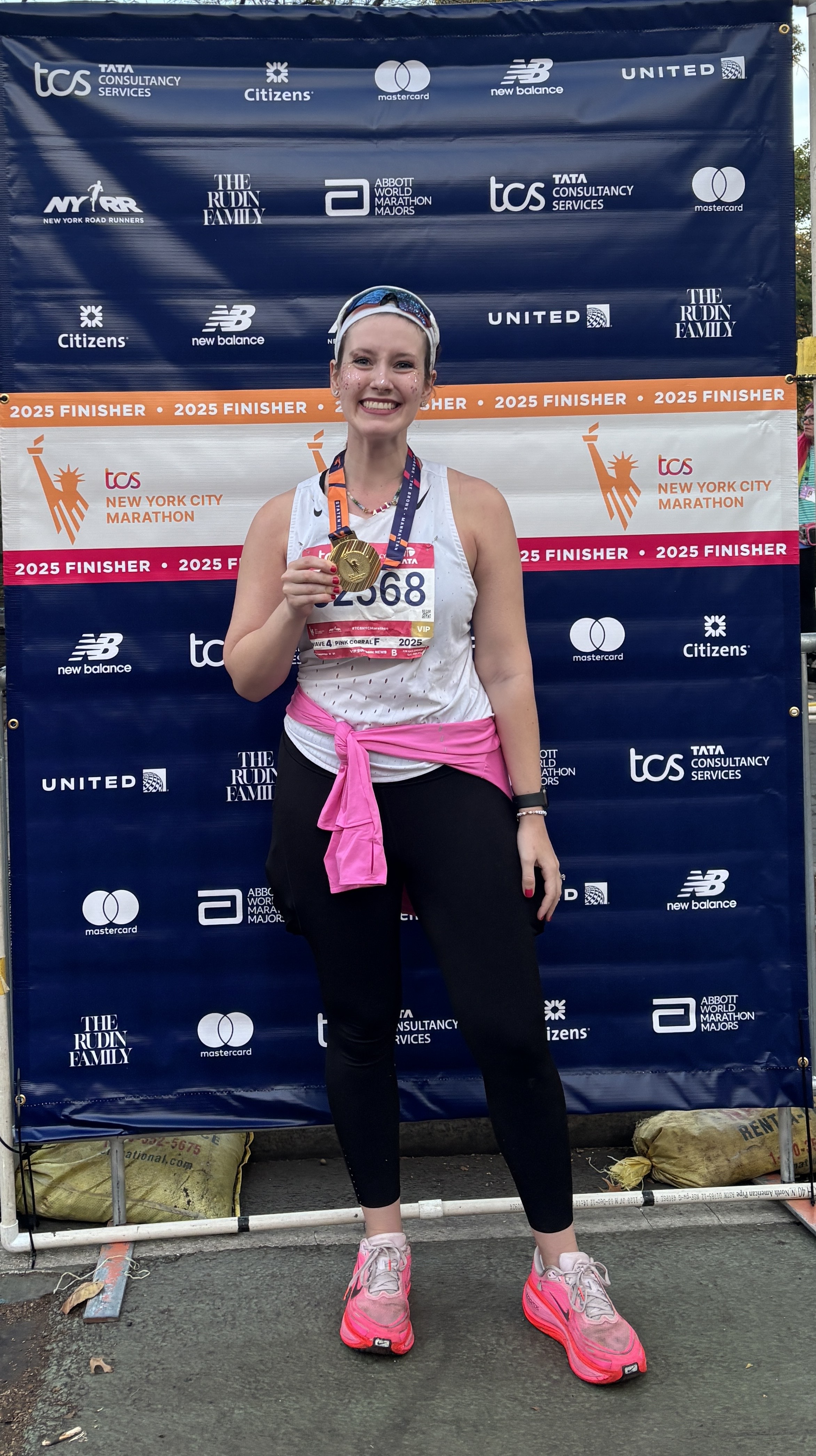 Halie LeSavage at the 2025 New York City Marathon finish line wearing full makeup
