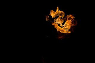 Fire plume illuminated on a black background.