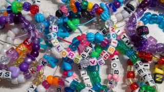 A pile of friendship bracelets, with one that says "Taylor's Version" at the top.