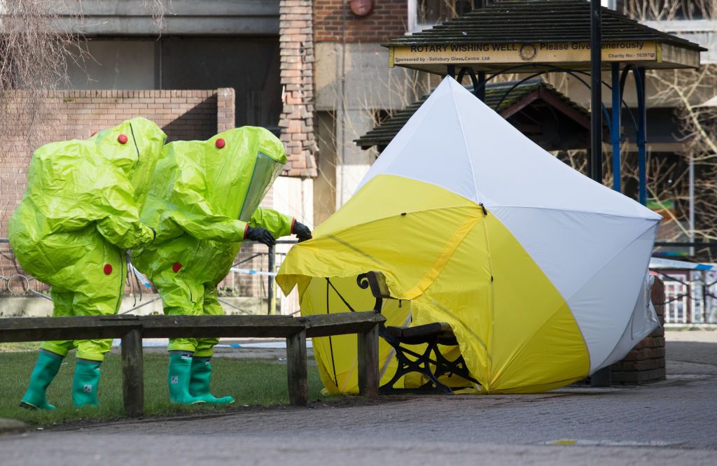  Specialist officers in protective suits secure the police forensic tent that had been blown over by the wind and is covering the bench where Sergei Skripal was found critically with his daug