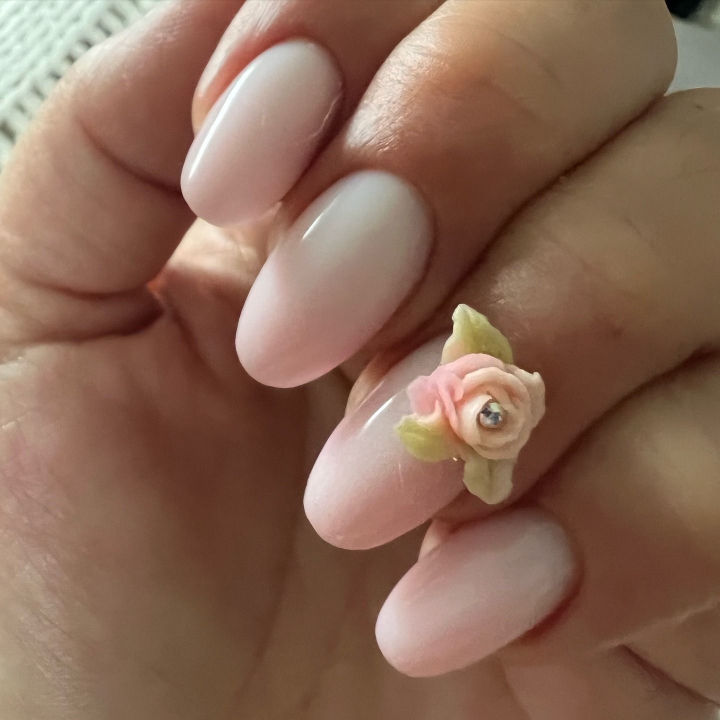 neutral pink nails with a flower accent