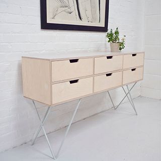 white room with sideboard and potted plant