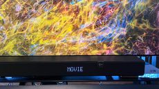 Klipsch Flexus Core 200 soundbar on TV stand with colorful abstract image on screen