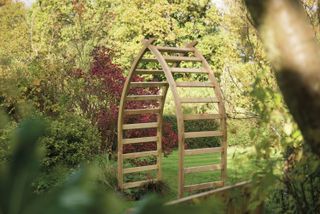 wooden archway dividing two areas of a garden